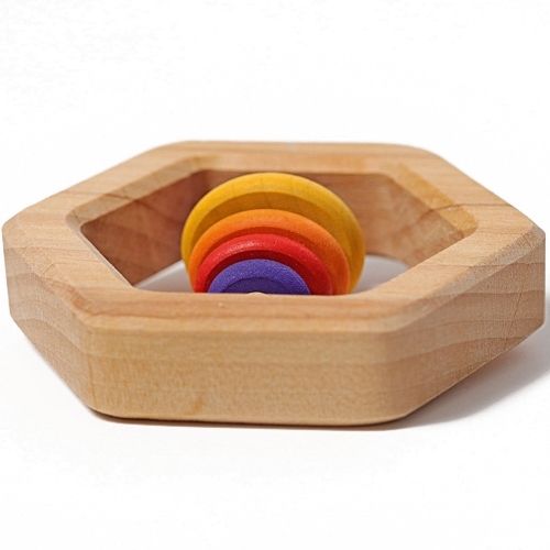 Grimm's houten zeshoekige rammelaar met regenboogkleurige ringen, van bovenaf gezien.