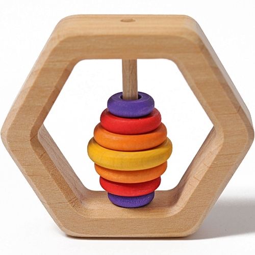 Vooraanzicht van de Grimm's houten zeshoekige rammelaar met regenboogkleurige ringen.