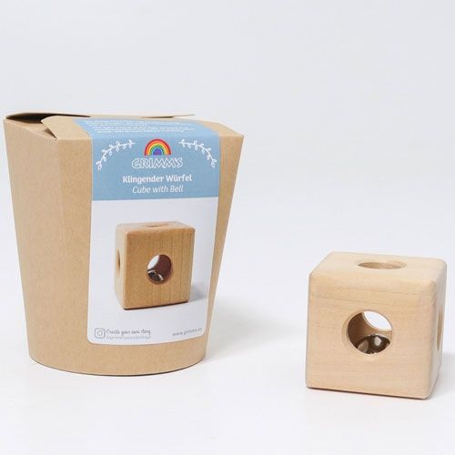 Grimm's houten rammelaar kubus naast de bruine verpakking met blauw label.