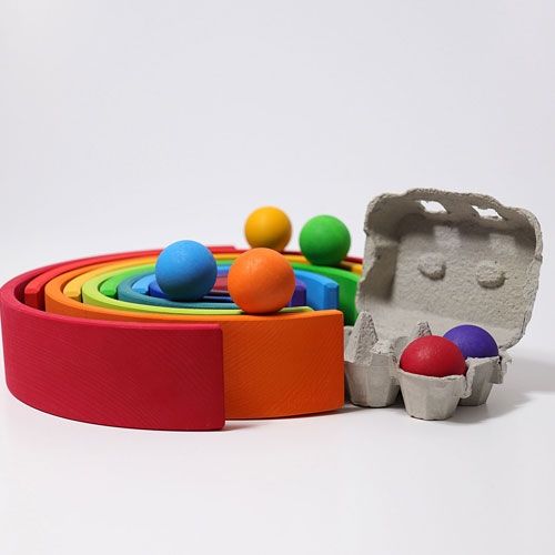 grimm's houten regenboog stapeltoren met gekleurde ballen en eieren in een eierdoosje.