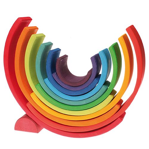De grimm's houten regenboog stapeltoren is in een open, waaiervormige halve cirkel opgesteld.