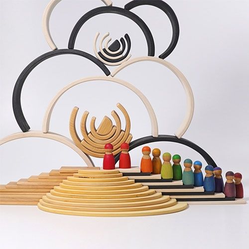 Een collectie Grimm's houten speelgoed met monochrome en natuurlijke regenboog stapeltorens, poppetjes en trappen.