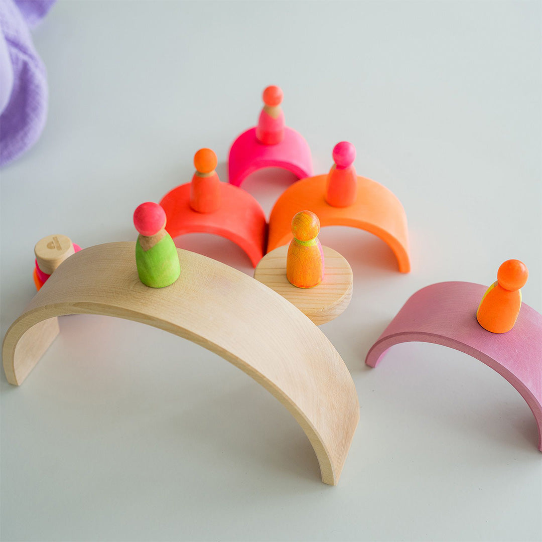 Detail van Grimm's houten regenboog stapeltoren bogen met houten peg dolls.