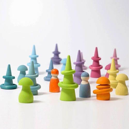 Een collectie grimm's pastelkleurige houten speelgoedfiguren en ringen op een witte ondergrond.