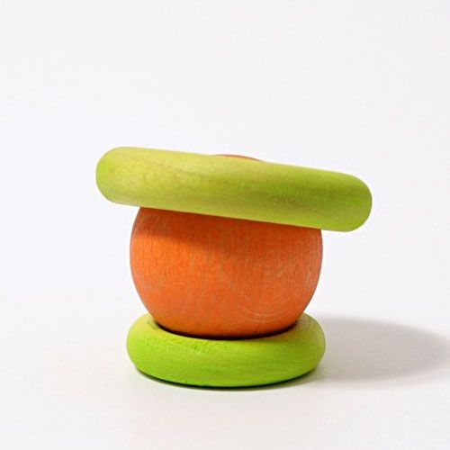 Een oranje houten bal met twee groene houten ringen erop gestapeld.