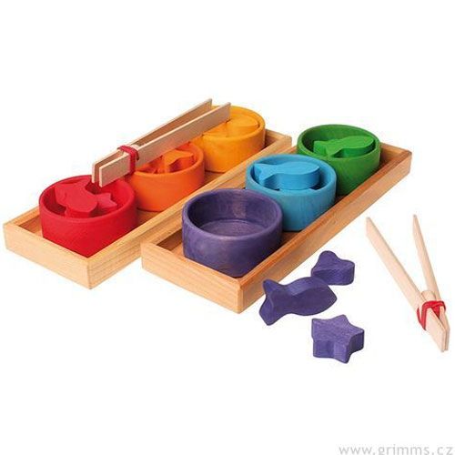 Grimm's sorteerspel met veelkleurige houten bakjes, vormen van dieren, sterren en harten, en twee pincetten.