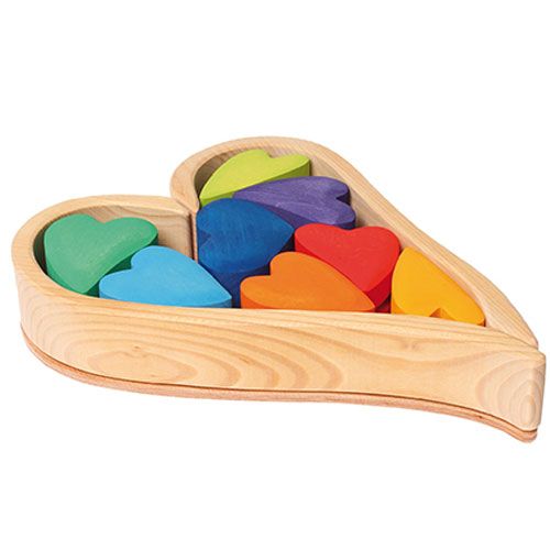 Grimm's houten stapel harten in regenboogkleuren, netjes gerangschikt in de hartvormige houten bak.