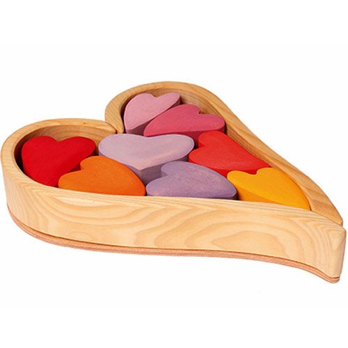 Grimm's houten stapelharten in een hartvormige schaal, gevuld met gekleurde houten hartjes.