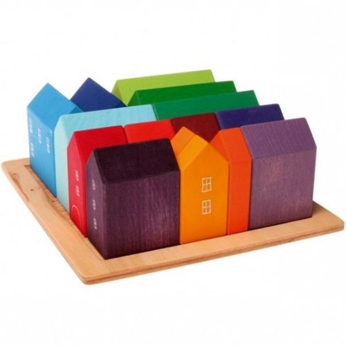Grimm's houten bouwblokken in de vorm van kleine, veelkleurige huisjes dicht op elkaar op een houten plaat.
