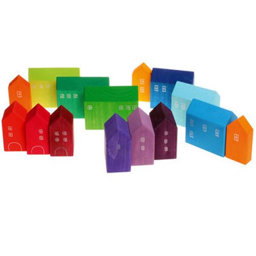 Grimm's houten bouwblokken in de vorm van kleine, veelkleurige huisjes los verspreid op een witte ondergrond.