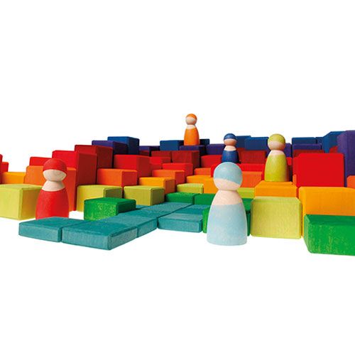 Grimm's houten bouwblokken en peg dolls vormen een kleurrijk landschap met een blauw pad.