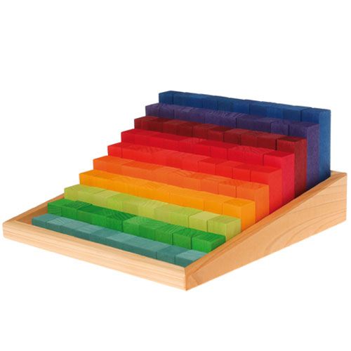 grimm's houten bouwblokken in regenboogkleuren, gerangschikt als een oplopende trap in een houten bak.