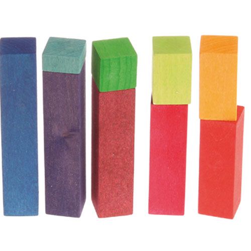 Detail van vijf paren grimm's houten bouwblokken in regenboogkleuren, elk met een rechthoekig blok en een kleiner vierkant blok erbovenop.