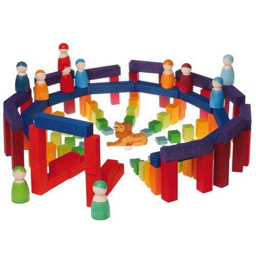 grimm's houten bouwblokken en peg dolls gebruikt om een kleurrijke arena met een leeuw en spiraal van blokken te bouwen.