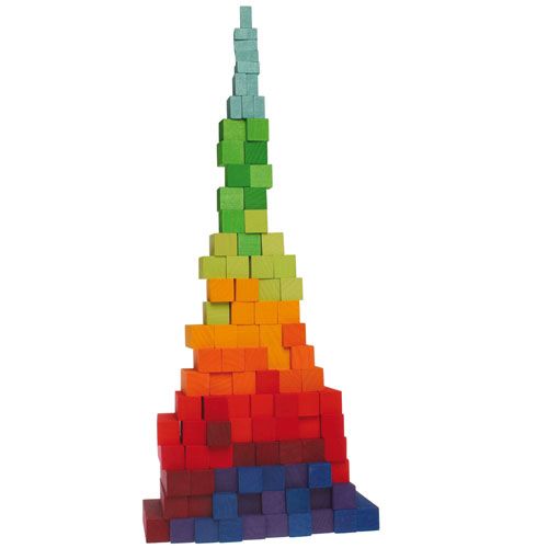 Een hoge, taps toelopende toren gebouwd van grimm's houten bouwblokken in regenboogkleuren.