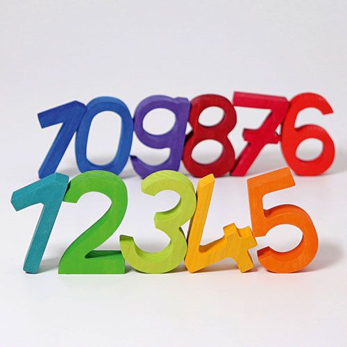 grimm's houten stapelcijfers 1 tot en met 5 in regenboogkleuren staan op de voorgrond, met andere cijfers wazig op de achtergrond.