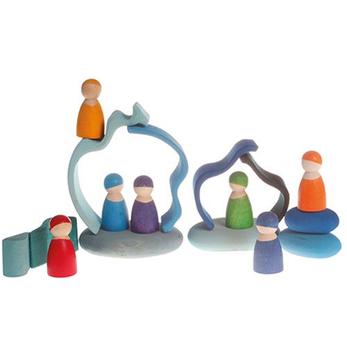 Een Grimm's houten speelset met gekleurde peg dolls, blauwe golfvormige bogen en gestapelde kiezelstenen.