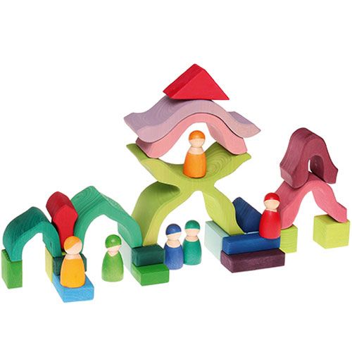 Grimm's houten bouwspeelgoed met gekleurde blokken en houten poppetjes, opgesteld als een speellandschap.