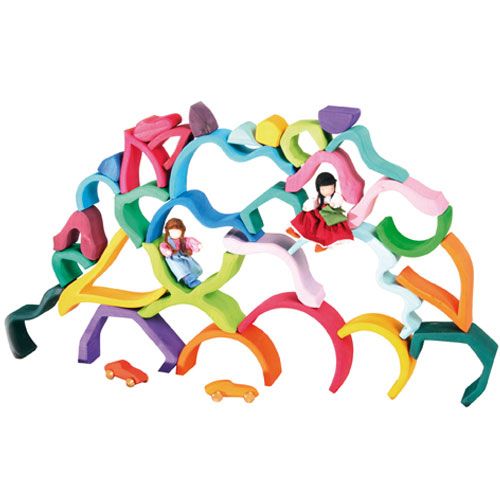 Grimm's houten bouwspeelgoed met een grote constructie van veelkleurige blokken, met twee poppetjes en twee autootjes.
