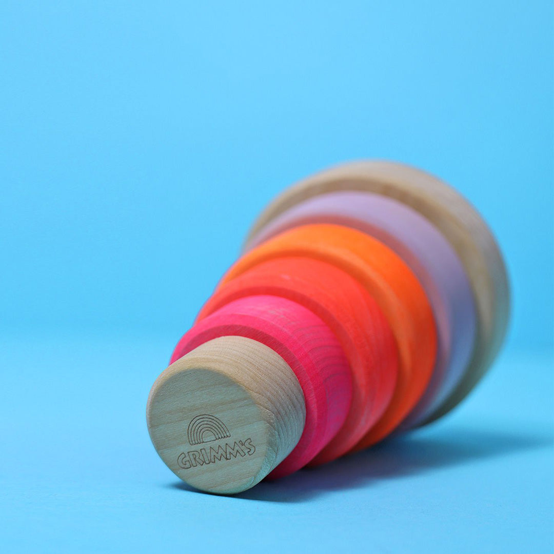 Grimm's houten stapeltoren voor baby's ligt op zijn zij, met het Grimm's logo zichtbaar op de onderkant.