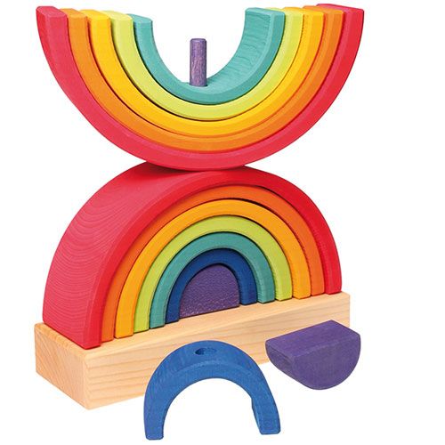 Grimm's houten regenboog stapeltoren met twee gestapelde halve bogen op een houten basis en losse onderdelen ervoor.