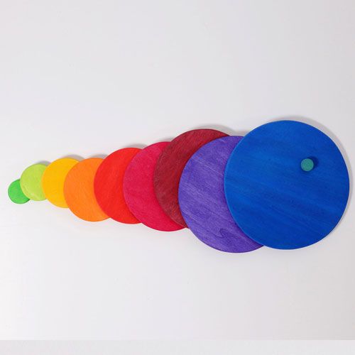 grimm's houten stapelspeelgoed met regenboogkleurige schijven op een rij, van klein naar groot.