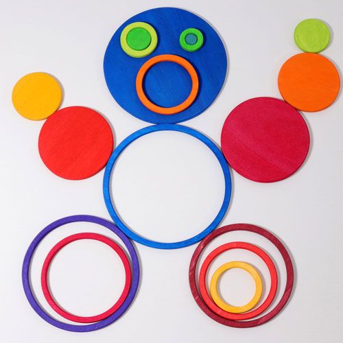 grimm's houten stapelspeelgoed met regenboogkleurige schijven en ringen die een figuur vormen.