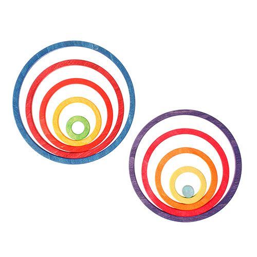 Twee sets grimm's houten stapelspeelgoed met in elkaar passende regenboogkleurige ringen.