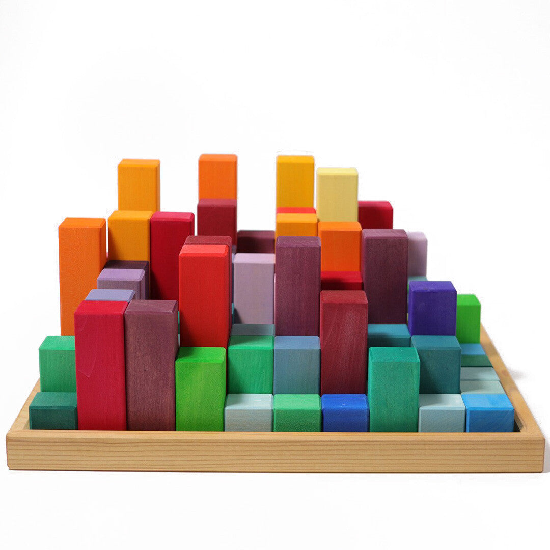 Grimm's houten trappiramide blokken in een houten bak, opgebouwd als een veelkleurige stad met verschillende hoogtes.