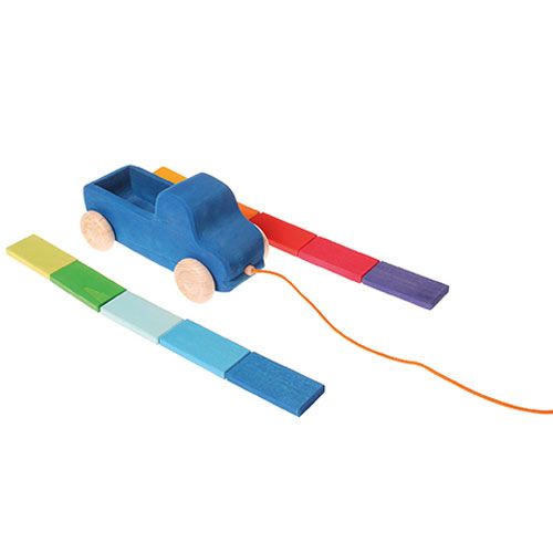 Grimm's houten trekfiguur vrachtwagen met de regenboogkleurige blokken in twee rijen ernaast.