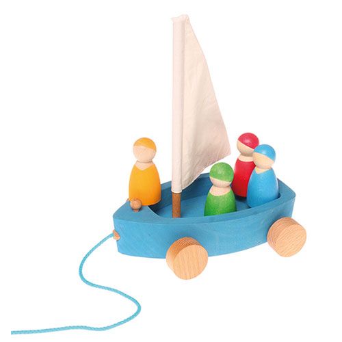 Grimm's houten trekfiguur zeiljacht met vier kleurrijke zeilers en een wit stoffen zeil.