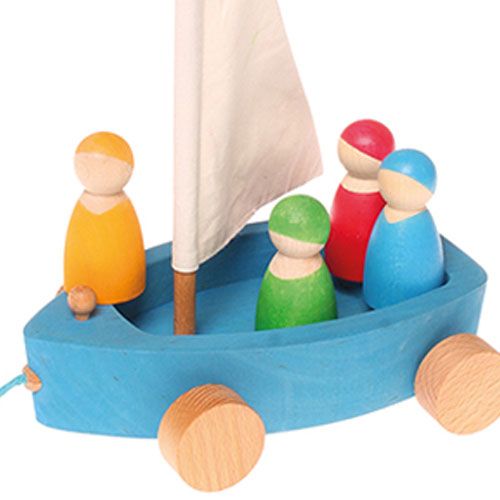 Detail van het blauwe houten zeiljacht met de vier kleurrijke houten zeilers.