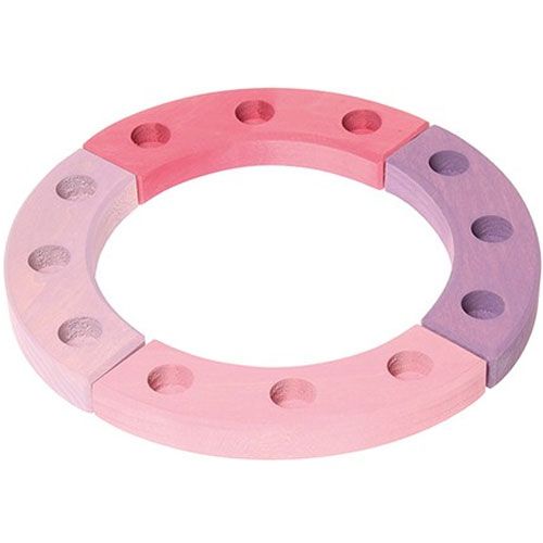 Een grimm's houten verjaardagsring in roze en paarse tinten met gaten voor decoraties.
