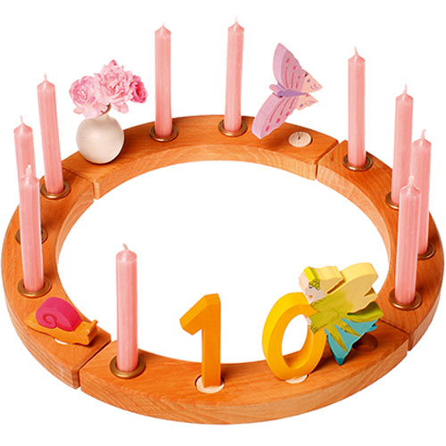 Grimm's houten verjaardagsring versierd met roze kaarsen, bloemen, een vlinder, een slak en de cijfers 10.
