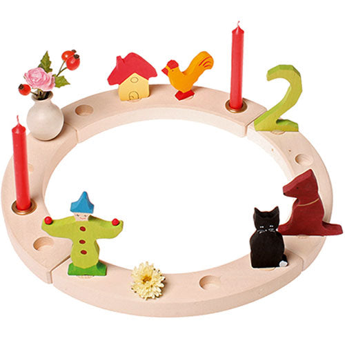 Grimm's houten verjaardagsring versierd met kaarsen en houten figuren.