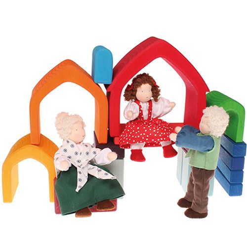 Grimm's houten huisvormen voor peuters, opgesteld als speelset met drie stoffen poppen.