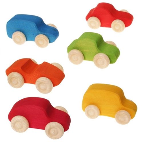 Zes grimm's houten speelgoedauto's in verschillende kleuren, met houten wielen.