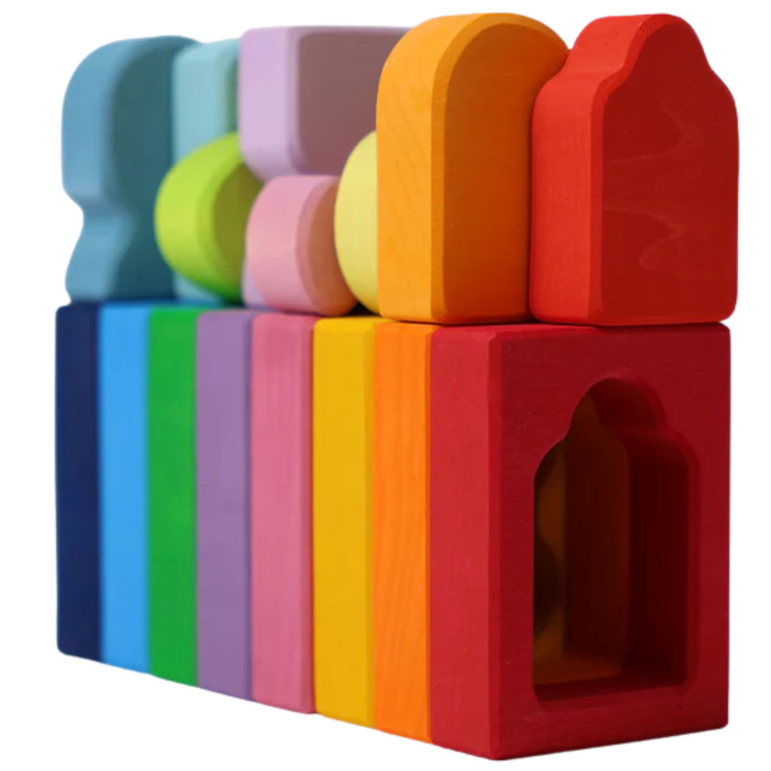 Grimm's houten bouwblokken in regenboogkleuren, met zowel frameblokken als massieve blokken, op een rij geplaatst.