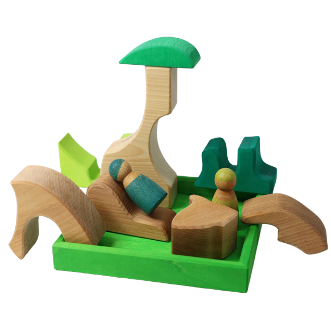 Grimm's houten bouwblokken set in een groene bak, opgesteld als een landschap.