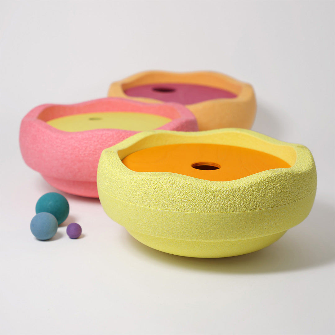 grimm's x stapelstein sorteer- en stapelspeelgoed met drie pastelkleurige komvormige elementen en drie losse houten ballen.