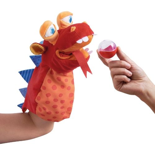 Haba handpop draak met open mond en een hand die een rammelaar aanbiedt.