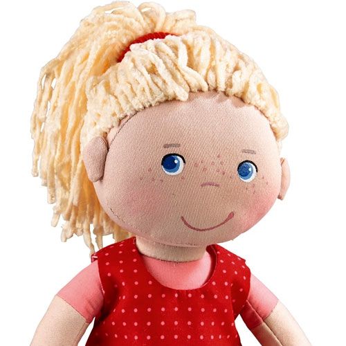 Detailopname van het gezicht van Haba lappenpop Annelie met blauwe ogen en blond haar.