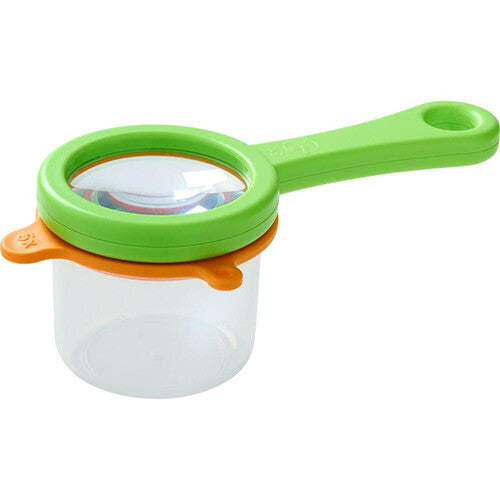 Haba bekerloep met groene handgreep en oranje ring op een doorzichtige beker.