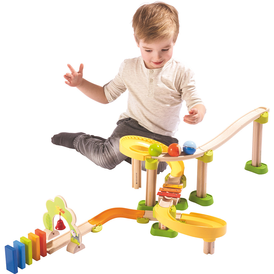 Een jongen speelt met de HABA Kullerbü knikkerbaan met kleurrijke figuren en ballen.