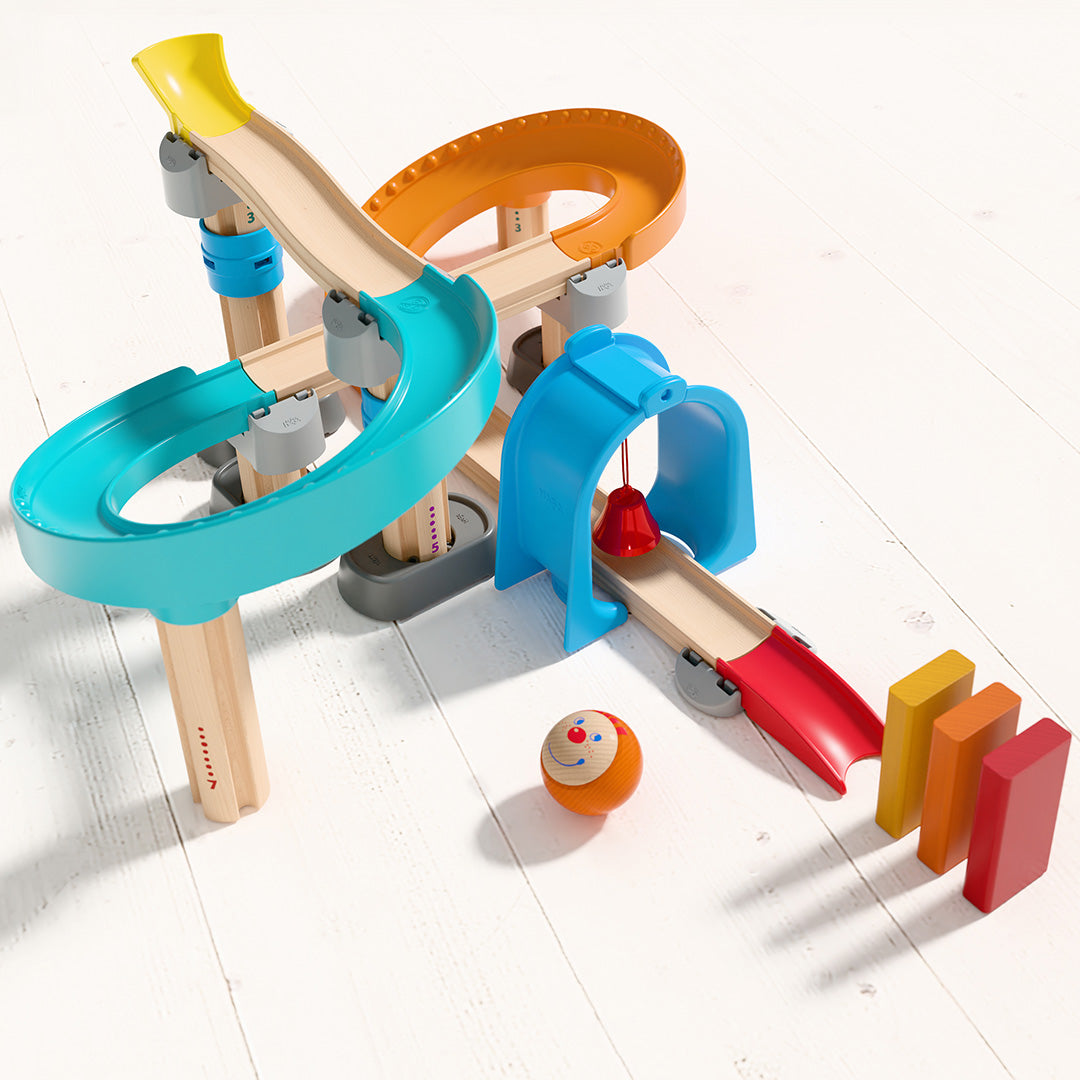 De HABA Kullerbü knikkerbaan 'Step-by-Step' opgebouwd met een knikker en gekleurde blokjes op een lichte houten vloer.