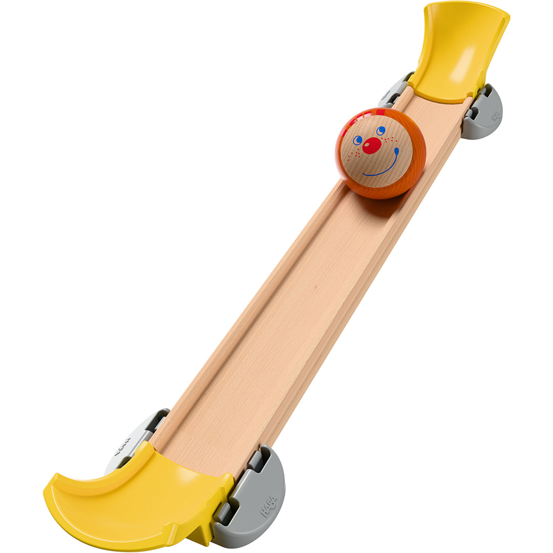 Detail van een houten knikkerbaanhelling met een lachende knikker met gezichtje van de HABA Kullerbü knikkerbaan.
