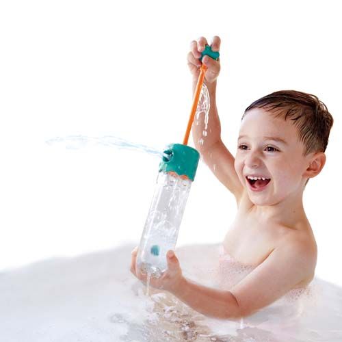 Een lachend kind in een bubbelbad speelt met de Hape waterspuit.