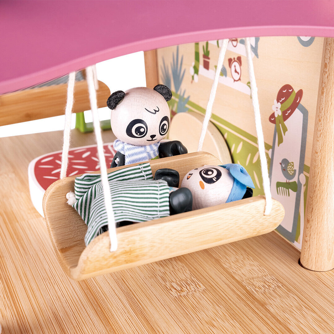 Detail van het Hape poppenhuis met een pandafiguur in een houten schommel en een andere panda ernaast.