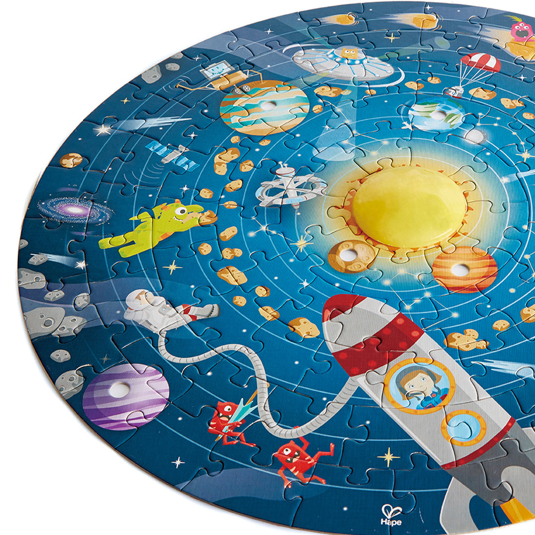 Detail van de Hape zonnestelsel legpuzzel met de zon, een raket, astronaut en diverse planeten.
