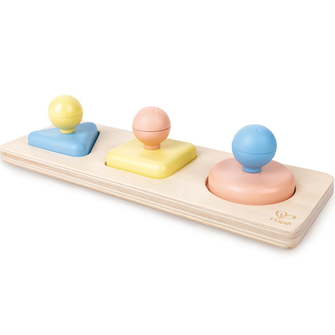 Hape houten vormenpuzzel met drie gekleurde vormen en knoppen op een lichte houten basis.